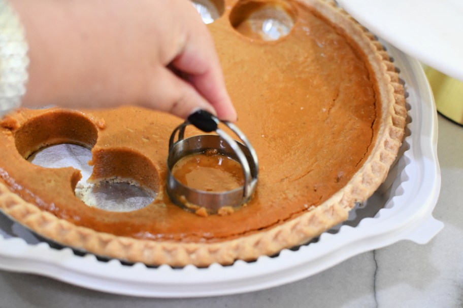 using a biscuit cutter to cut pumpkin pie