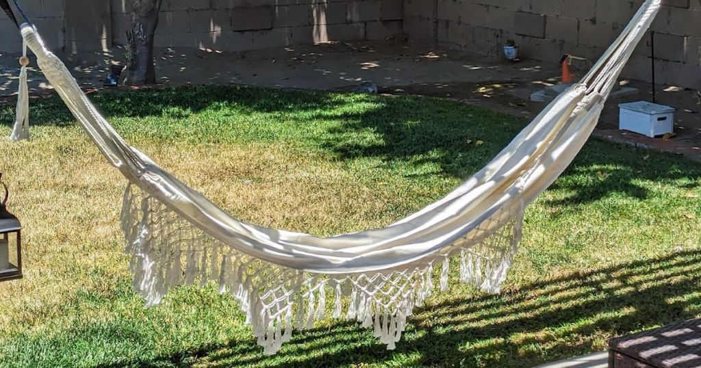 natural color hammock with fringe on a back deck