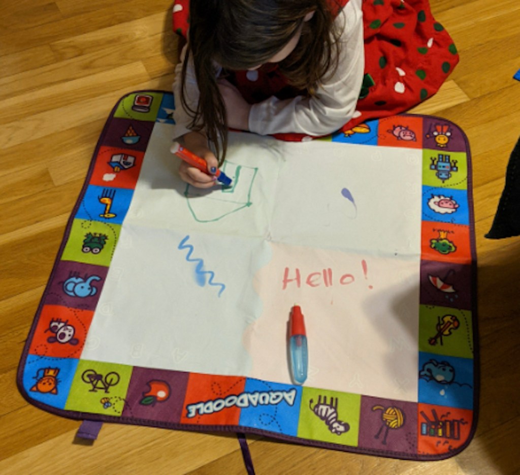 toddler coloring on aquadoodle on wood floor best toys for 2 year olds