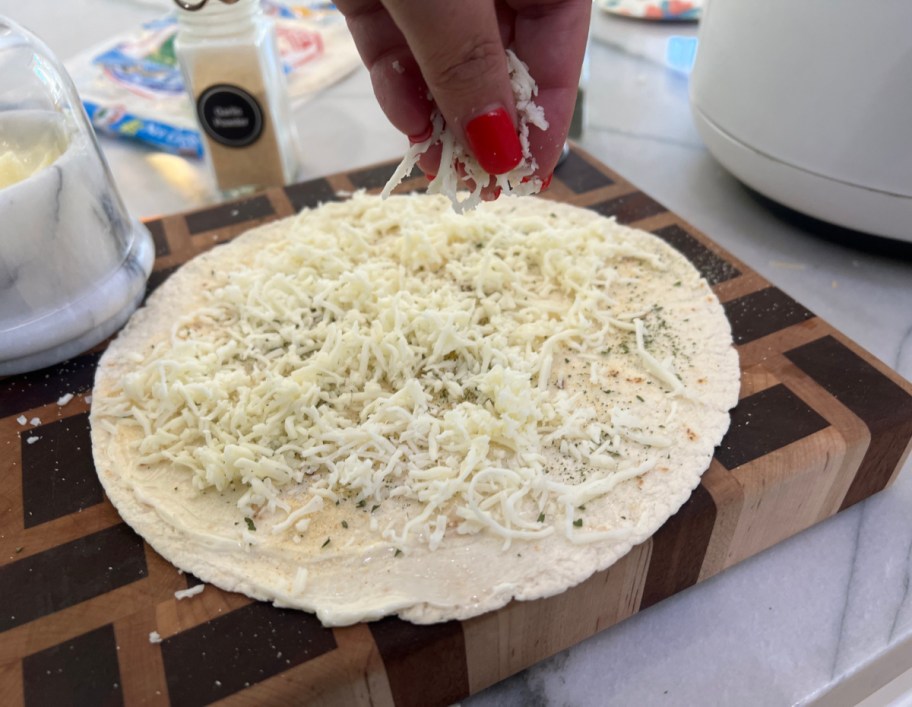 Sprinkling cheese on a tortilla
