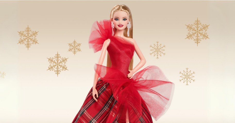 a blonde haired Barbie doll in a red holiday gown with a red top and red, green, and gold plaid skirt, on a gold background with snowflakes