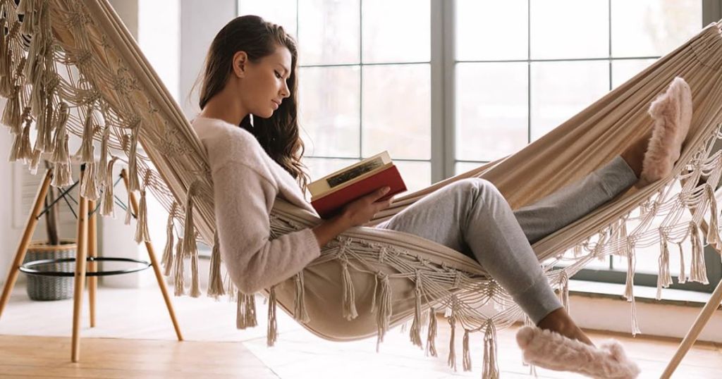 woman sitting in a fringe natural color hammock