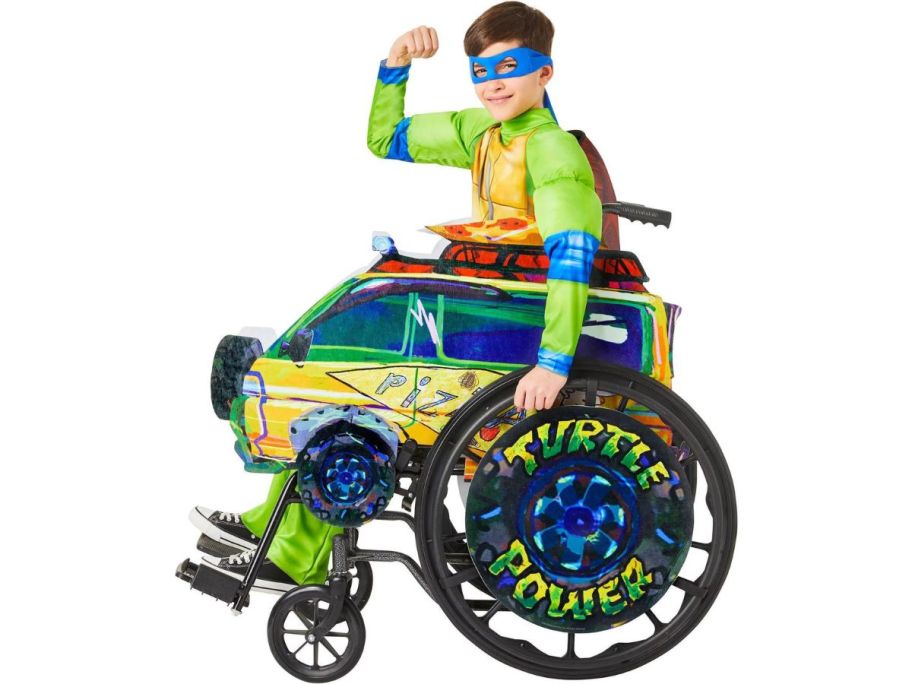 A boy wearing a Halloween costume sitting in a wheelchair