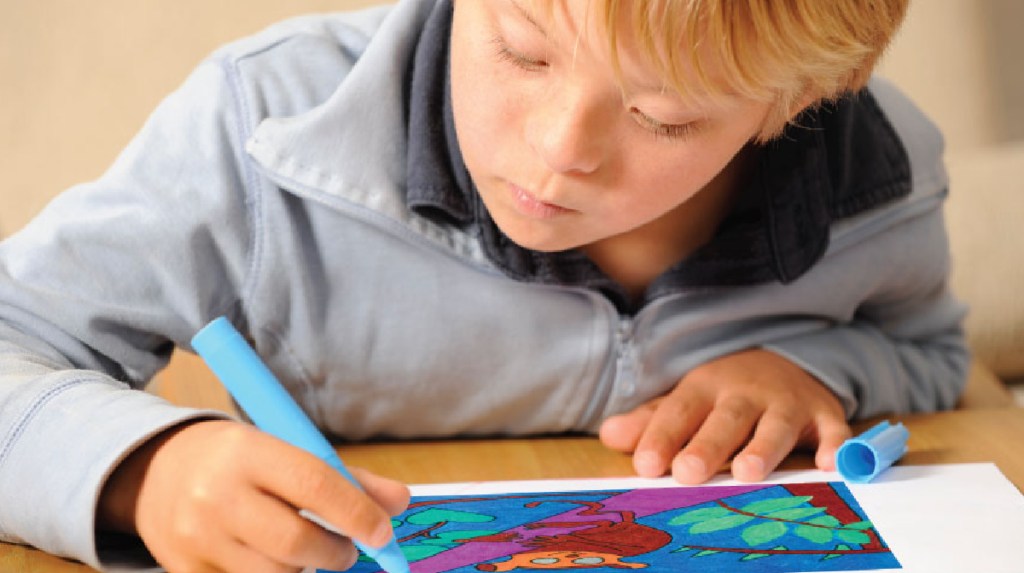 Child writing in a Studenttreasures Publishing Kit to become a published author