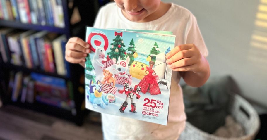 A sweet girl holding a Target Toy Catalog 2024