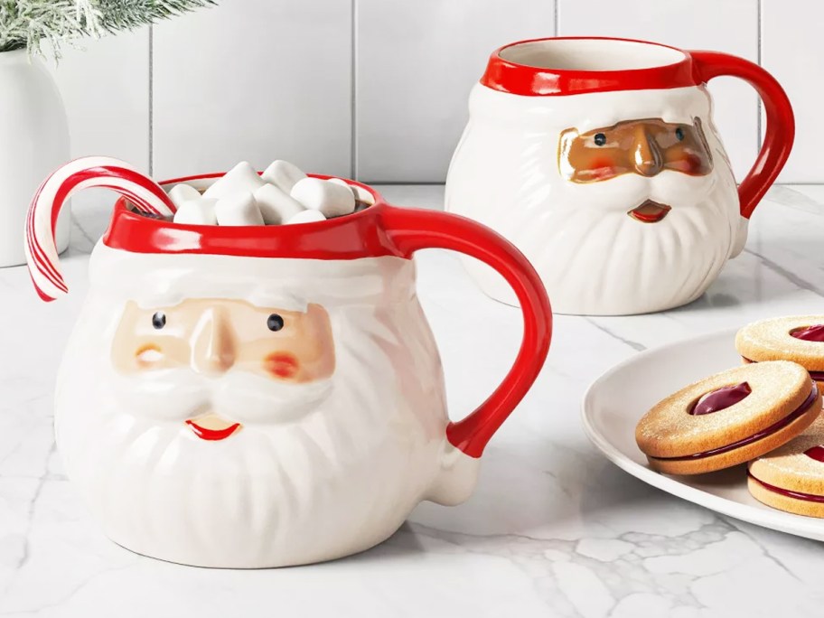 two santa face christmas mugs on kitchen counter