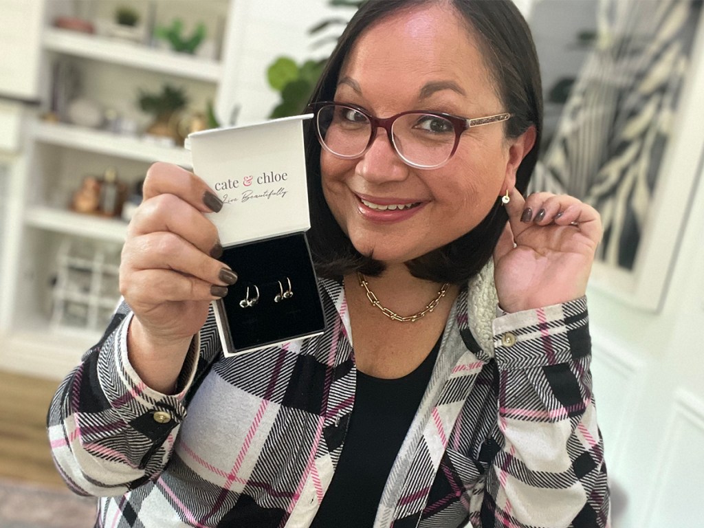 woman holding cate and chloe box with yellow gold earrings inside