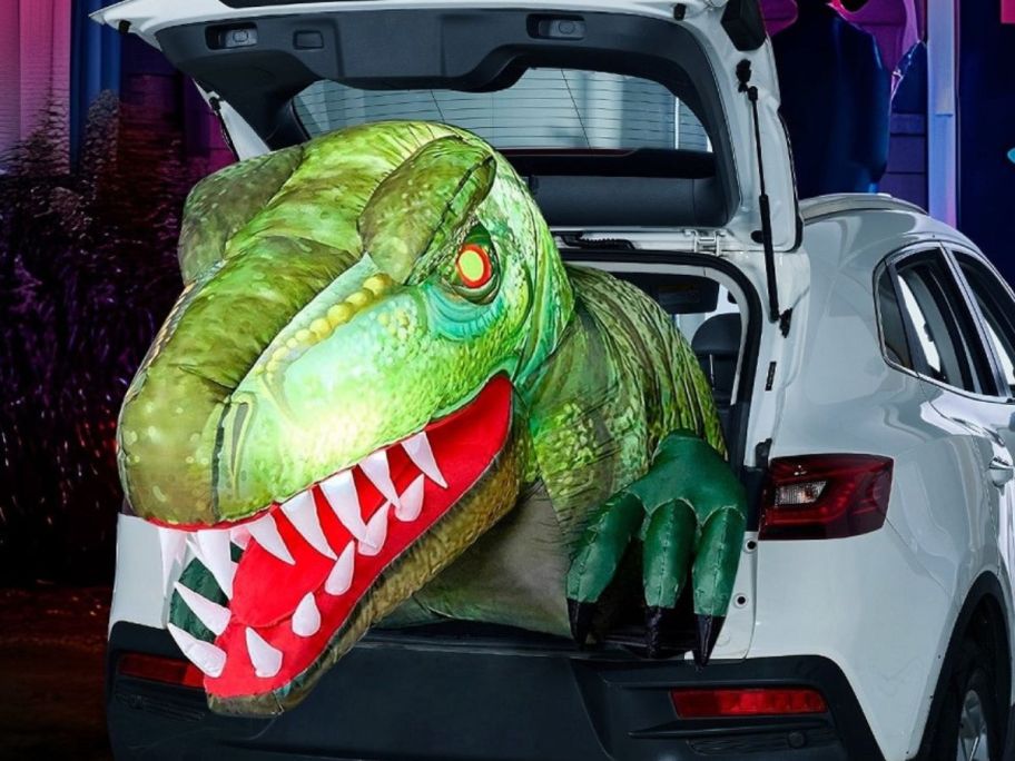 Inflated dino head coming out of a cars trunk for Halloween