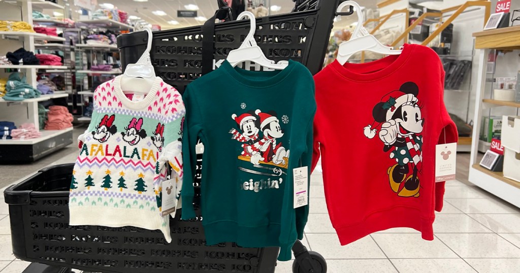 three kids disney sweaters hanging on kohls cart