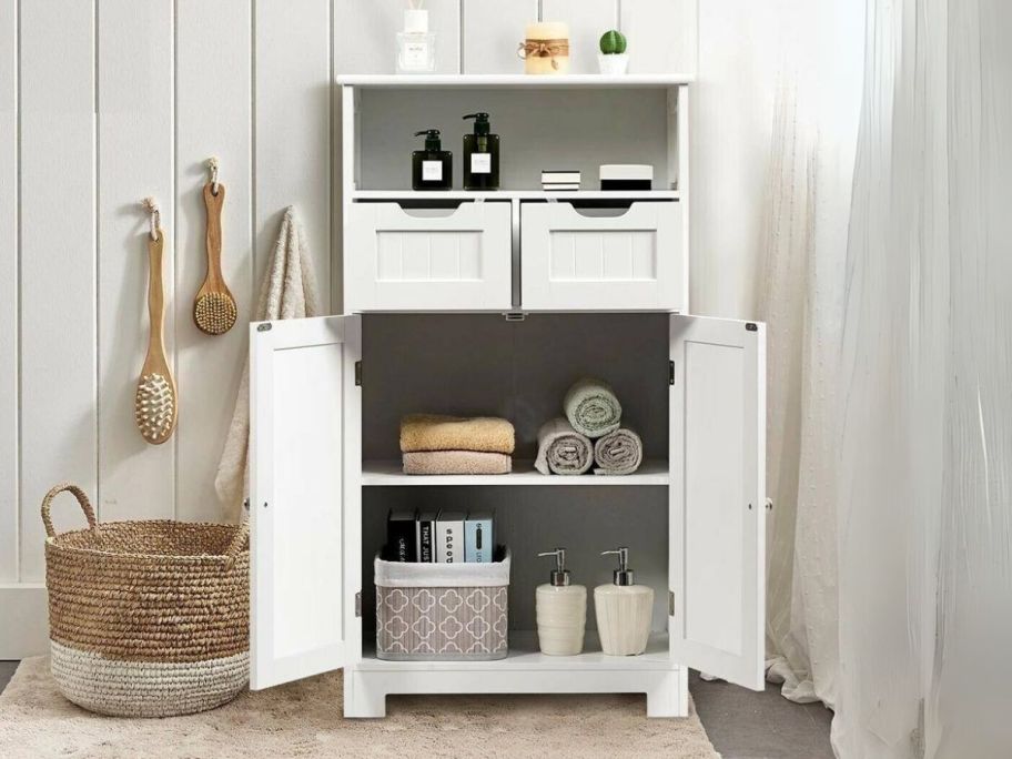 a white linen. cabinet with doors open showing storage space and contents