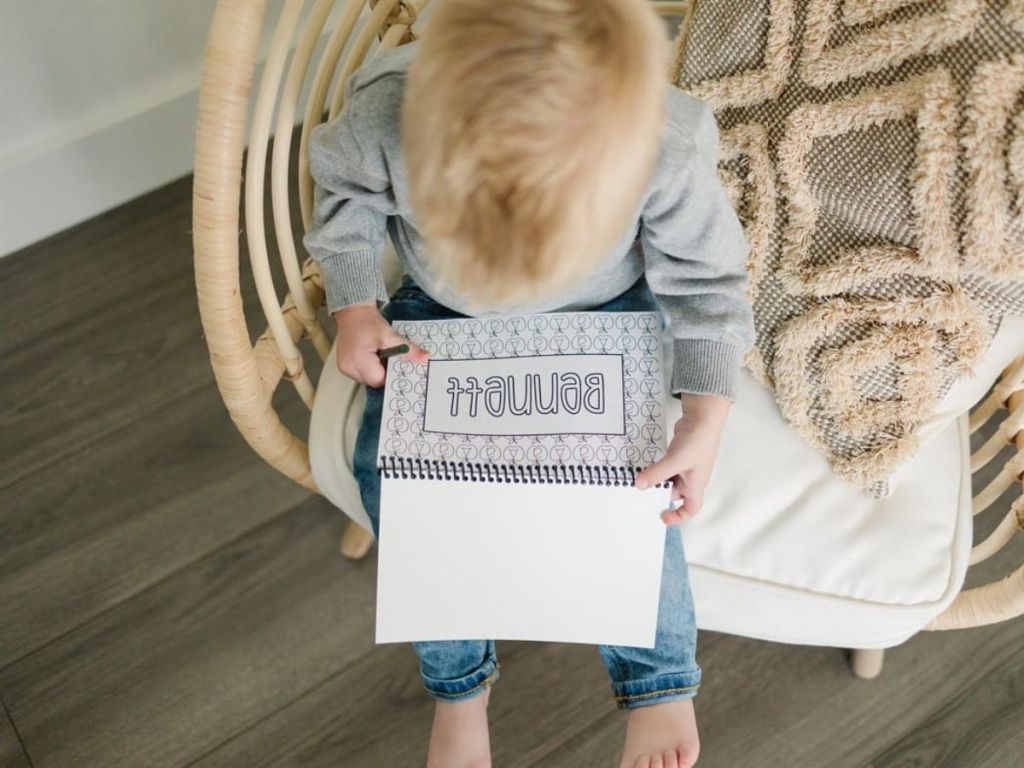 boy holding personalized coloring book on his lap