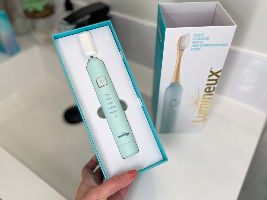 hand holding electric toothbrush in box