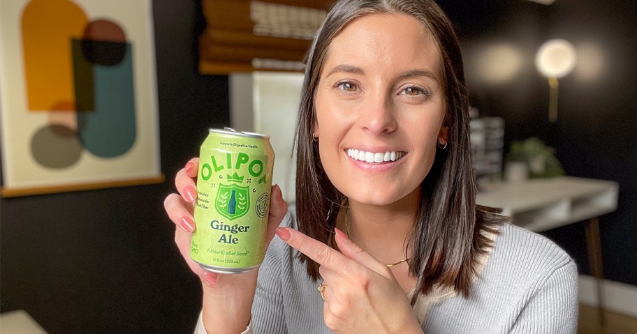 woman holding olipop soda can