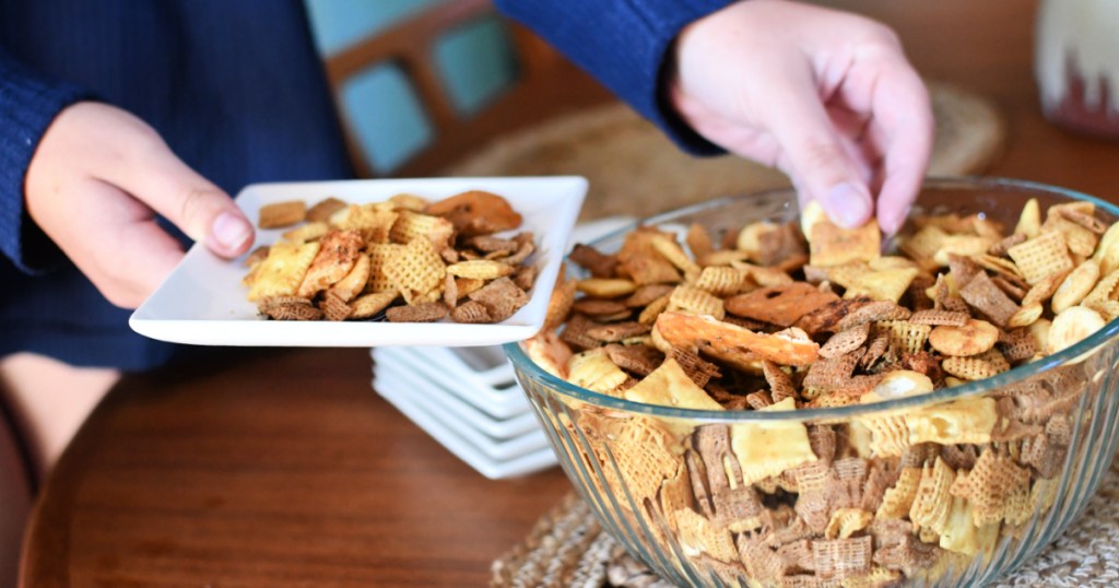 person grabbing homemade chex mix