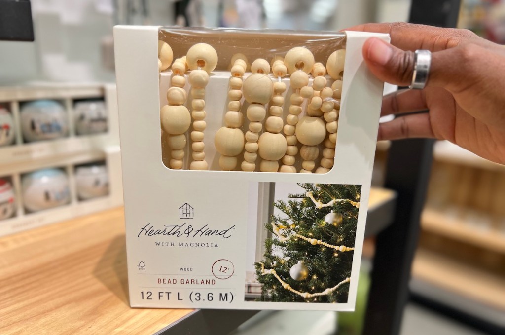 hand holding a box of wood bead garland 