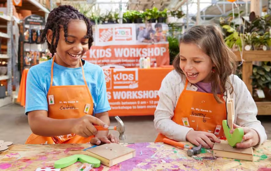 two kids wearing orange home depot aprons building craft