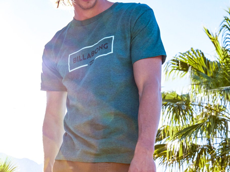 man wearing a teal billabong graphic tee