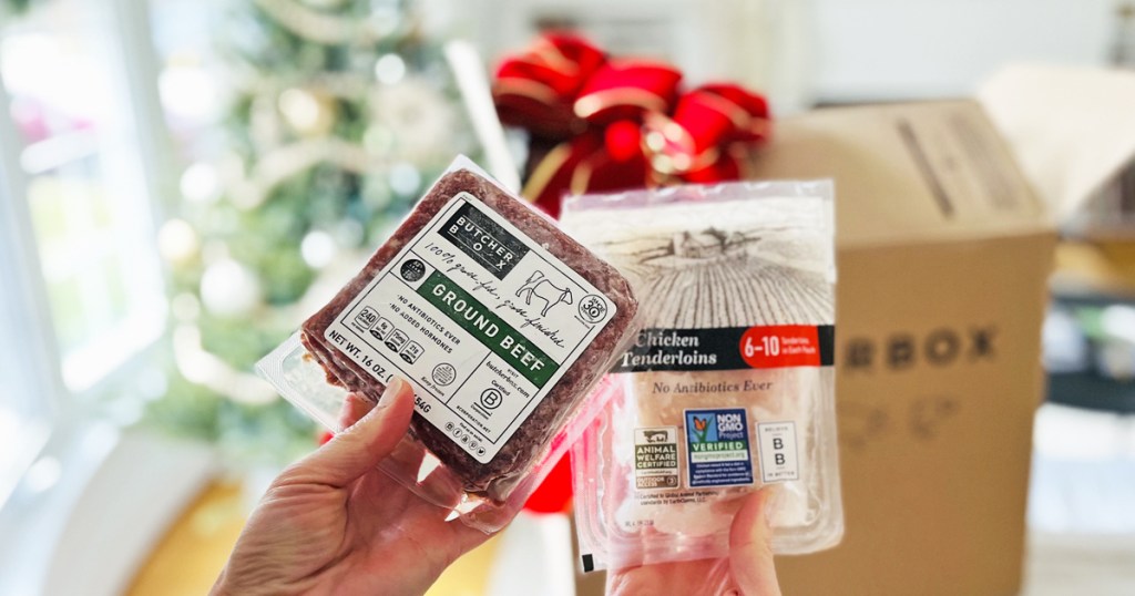 woman holding a pack of ground beef and a pack of chicken from Butcher box