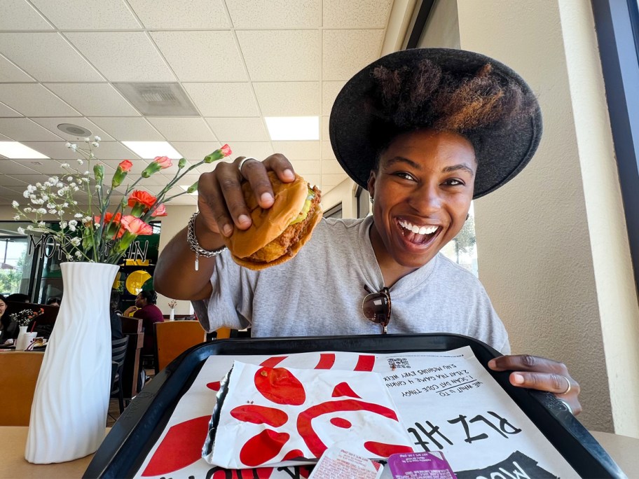 woman holding up a Chick-fil-A sandwich