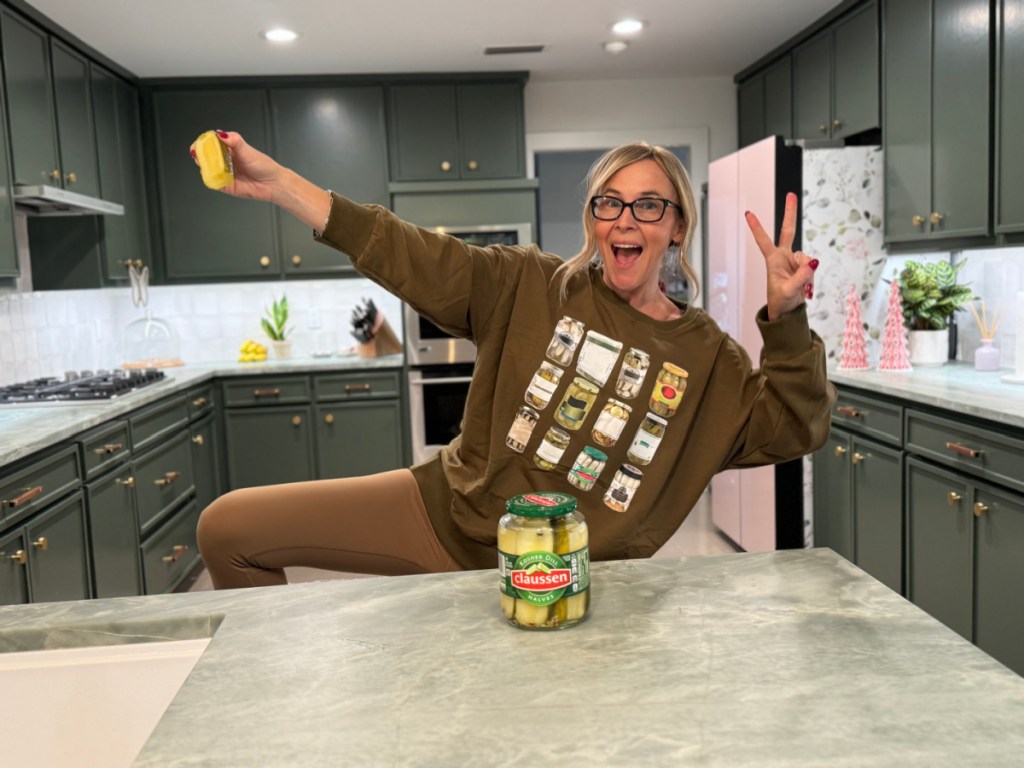 woman wearing pickle sweatshirt in kitchen