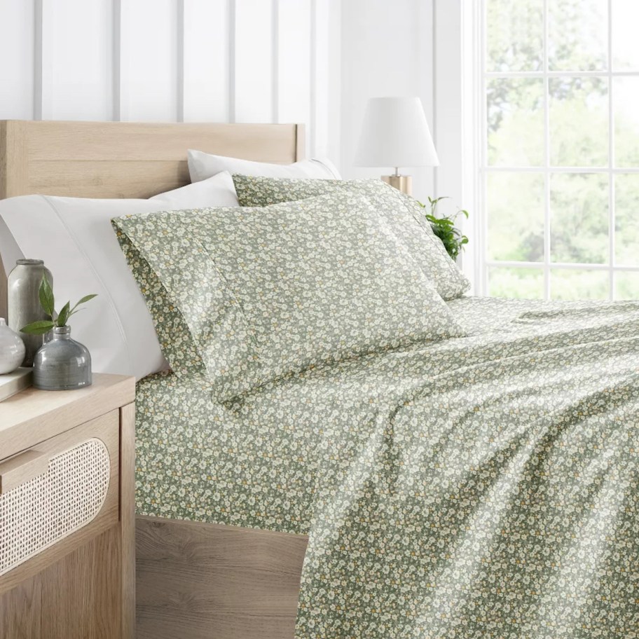 side of bed with green floral sheets