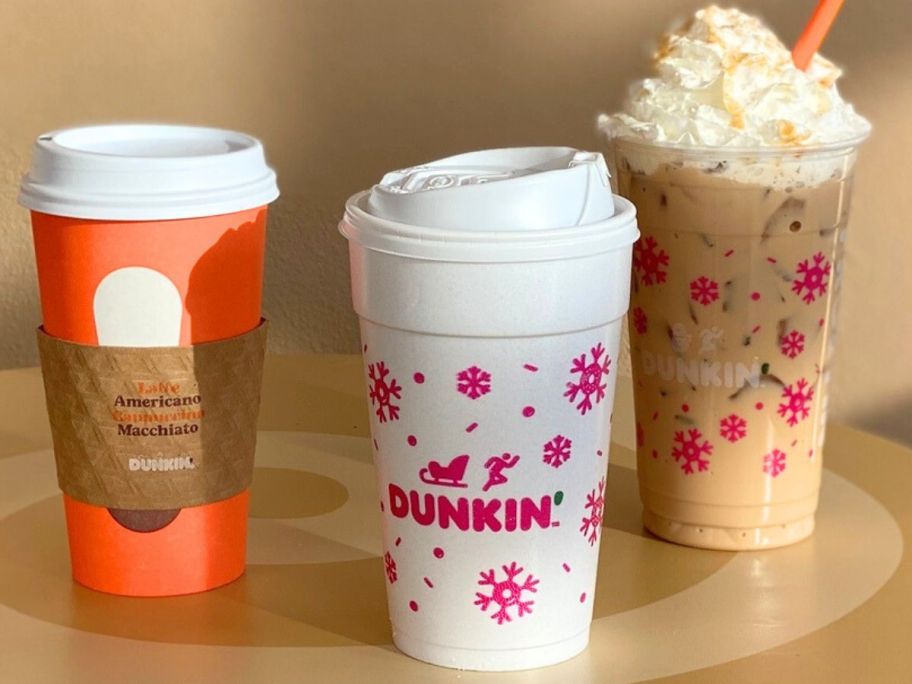 A Dunkin latte, coffee and iced coffee drink on a table