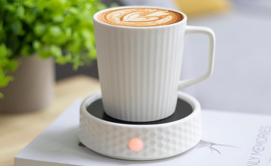 white coffee mug on white ceramic warming plate