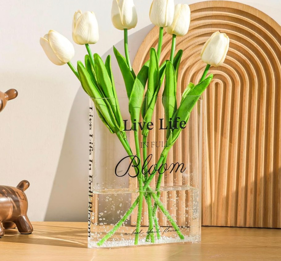 Clear acrylic book a vase with white tulips inside