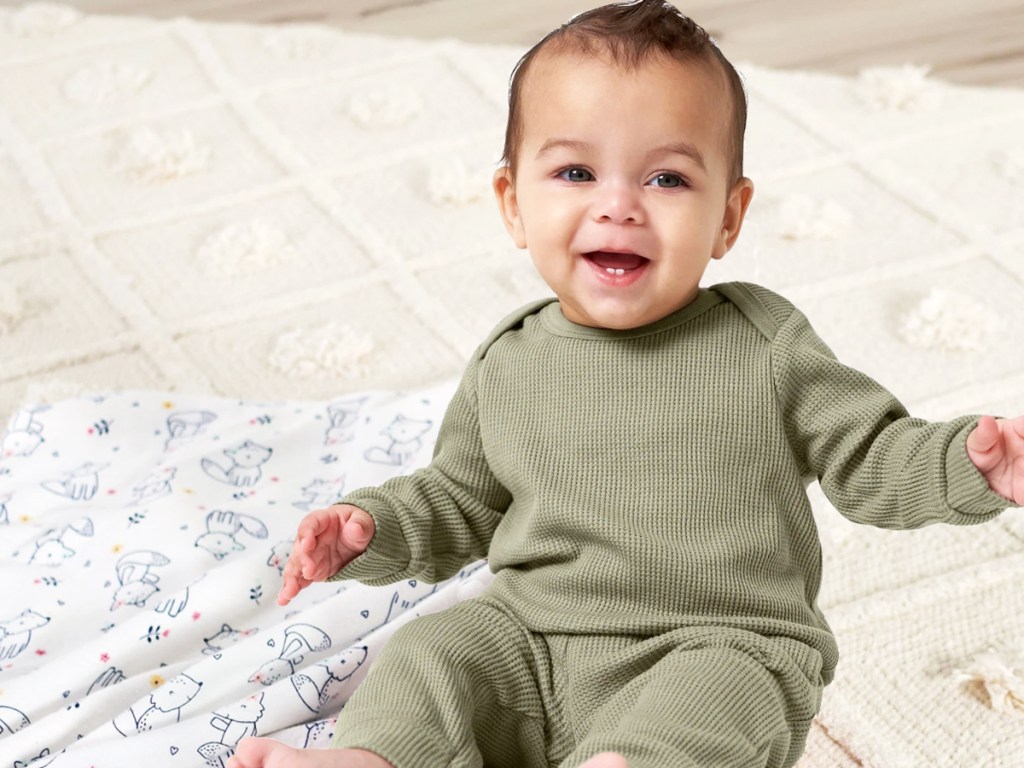 baby sitting on floor in matching green outfit set