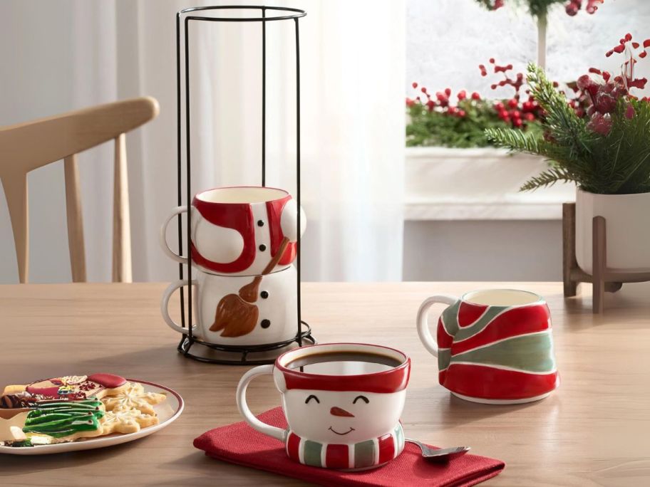 Holiday Time 12oz Snowman Glazed Stoneware Ceramic Stacking Mug Set w/ Metal Rack on table