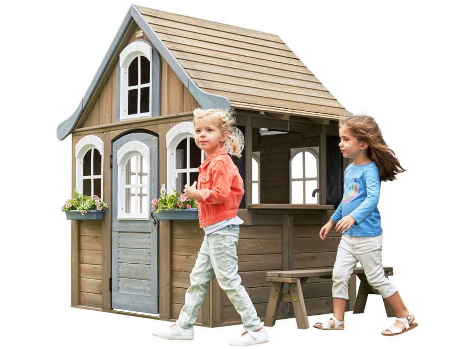 two girls in front of a wodden playhouse