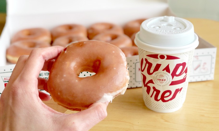 hand holding an original glazed krispy kreme doughnut, one of the birthday freebies and free birthday stuff you can get in 2024