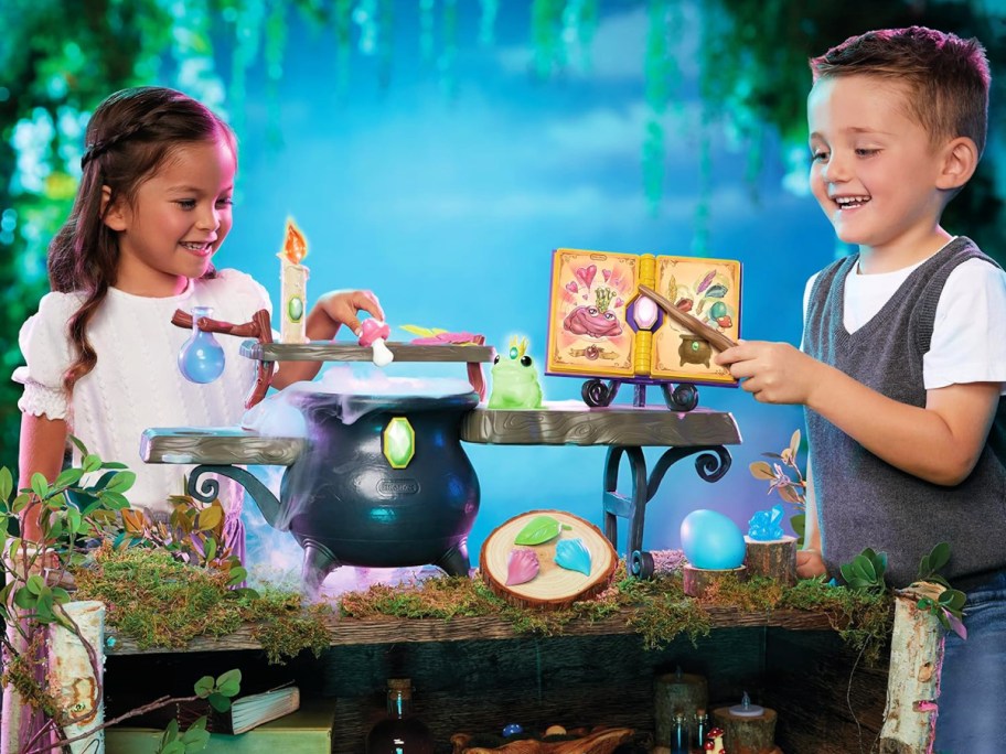 young boy and girl playing with a Little Tikes Magic Workshop