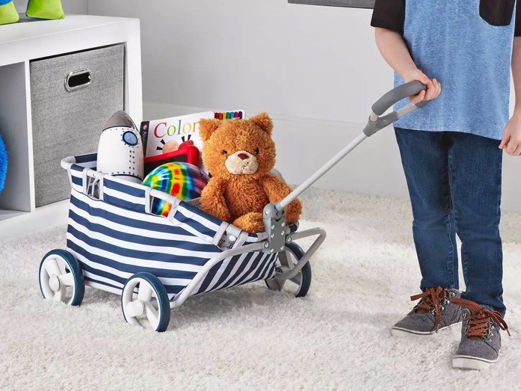 boy pulling a blue and white striped toy wagon