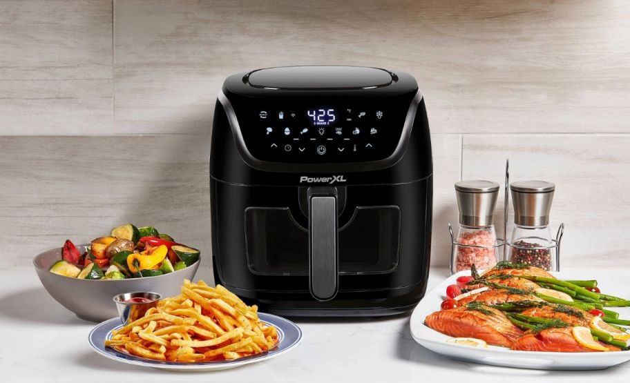 a power xl 8qt air fryer on a kitchen counter shown with bowls of prepared food
