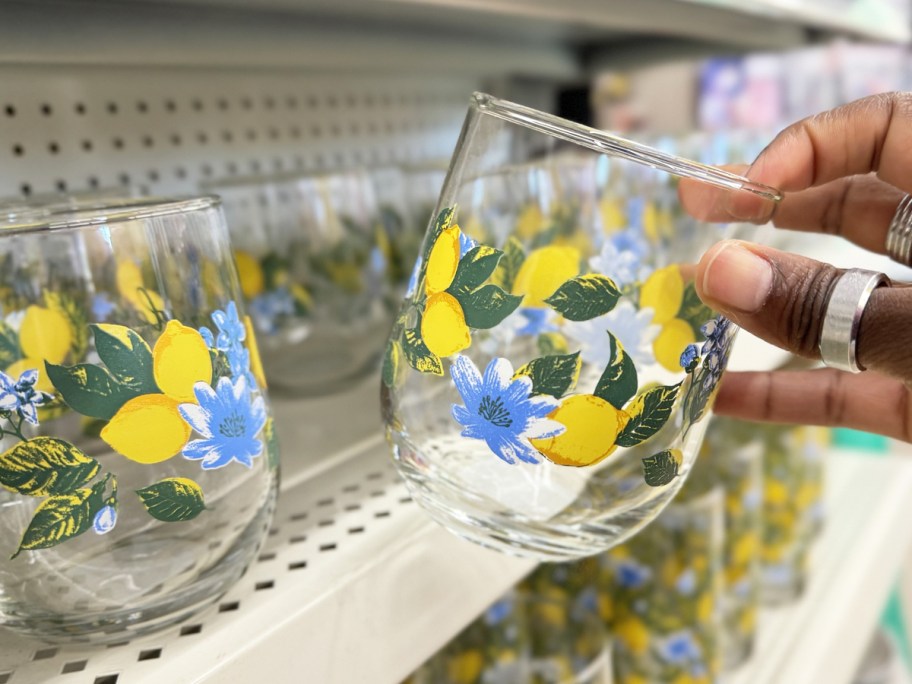hand holding up a lemon print stemless wine glass