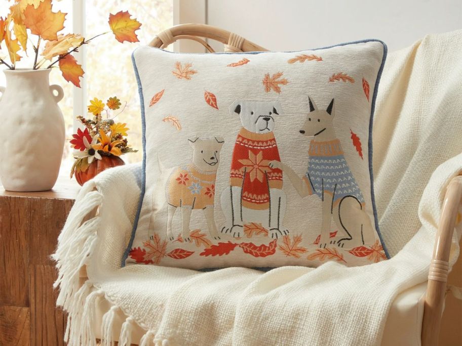 Decorative pillow with dogs on it laying on a couch