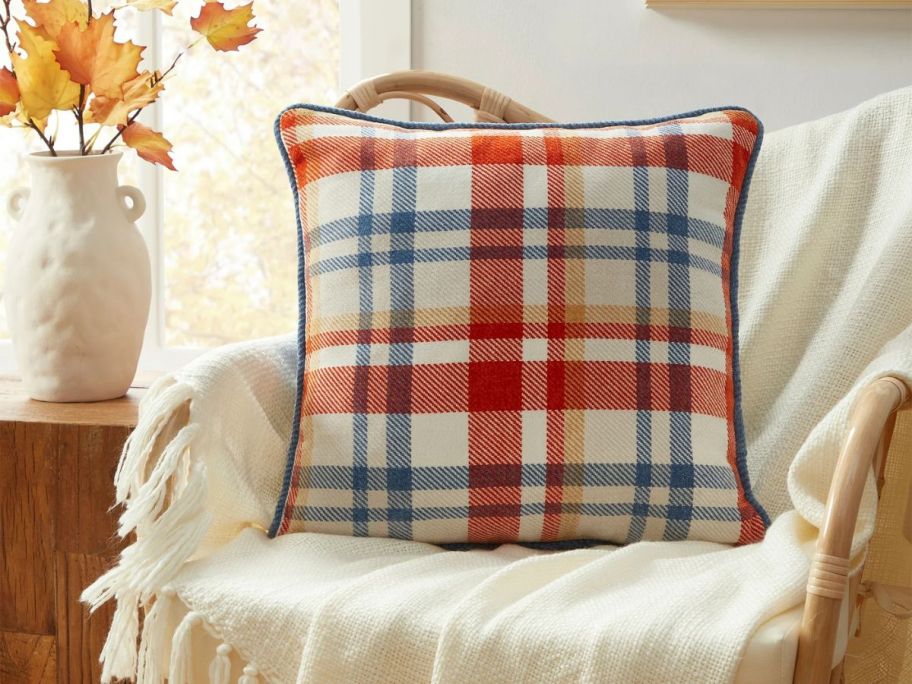 A blue and red plaid decorative pillow on a chair 