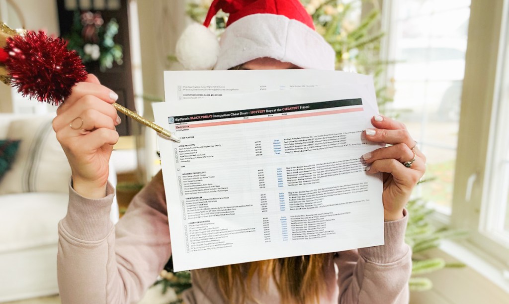 woman holding up black friday cheat sheet