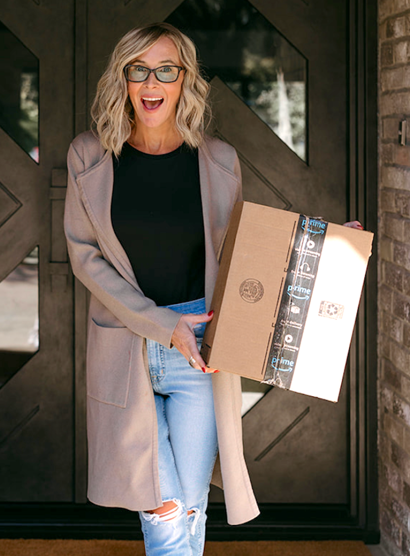 Collin wearing cardigan holding Amazon box 