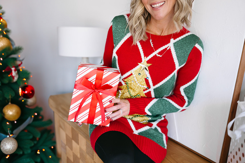 Collin holding Christmas gift wearing Ugly Christmas sweater 