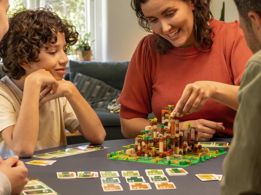 family playing Lego game on kitchen table