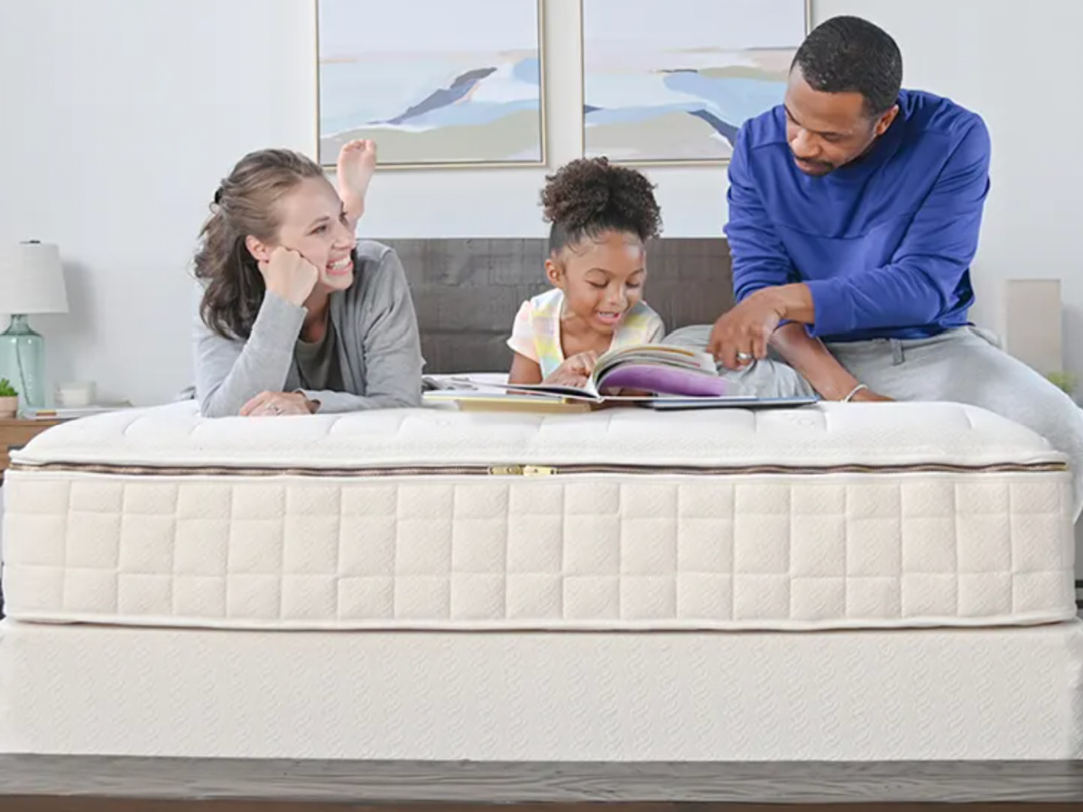 family sitting on bed