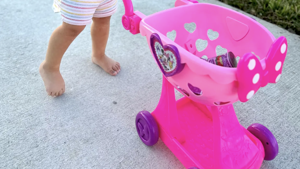 pushing pink Minnie Mouse shopping cart 