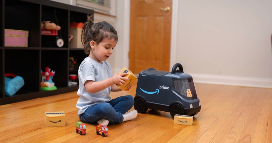 child playing on floor with Amazon ride-on toy