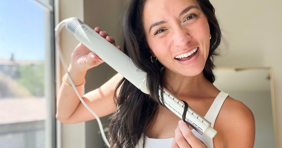 woman using white styler on hair