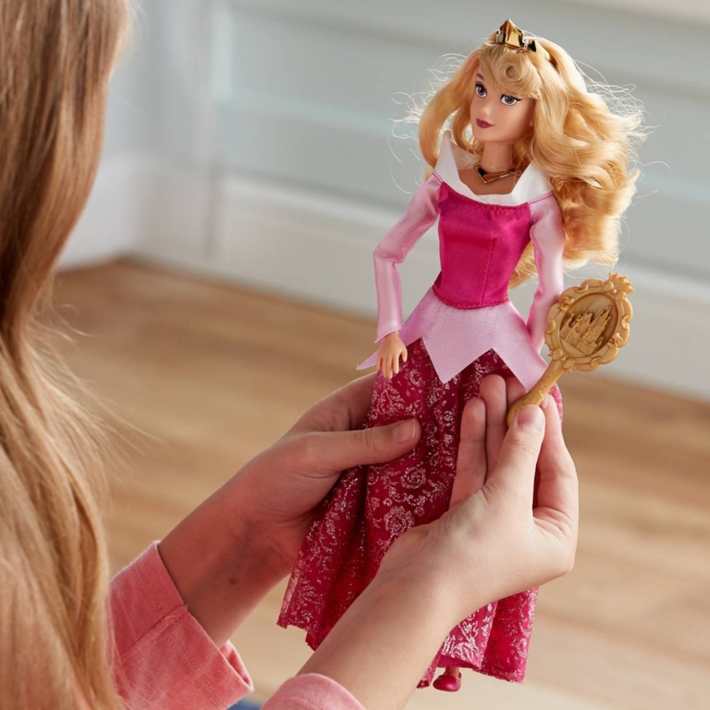 girl holding sleeping beauty doll