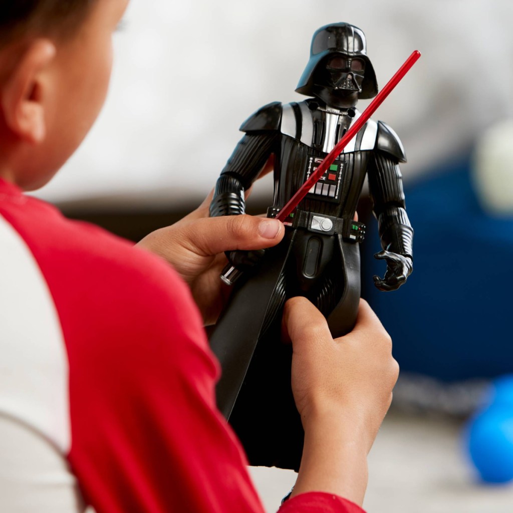 boy holding darth vader toy