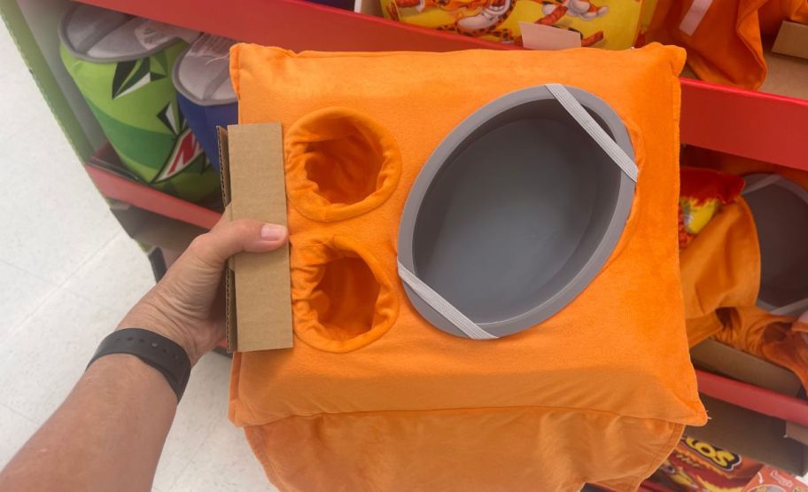 a womans hand showing a view of snack tray/ pillow interior