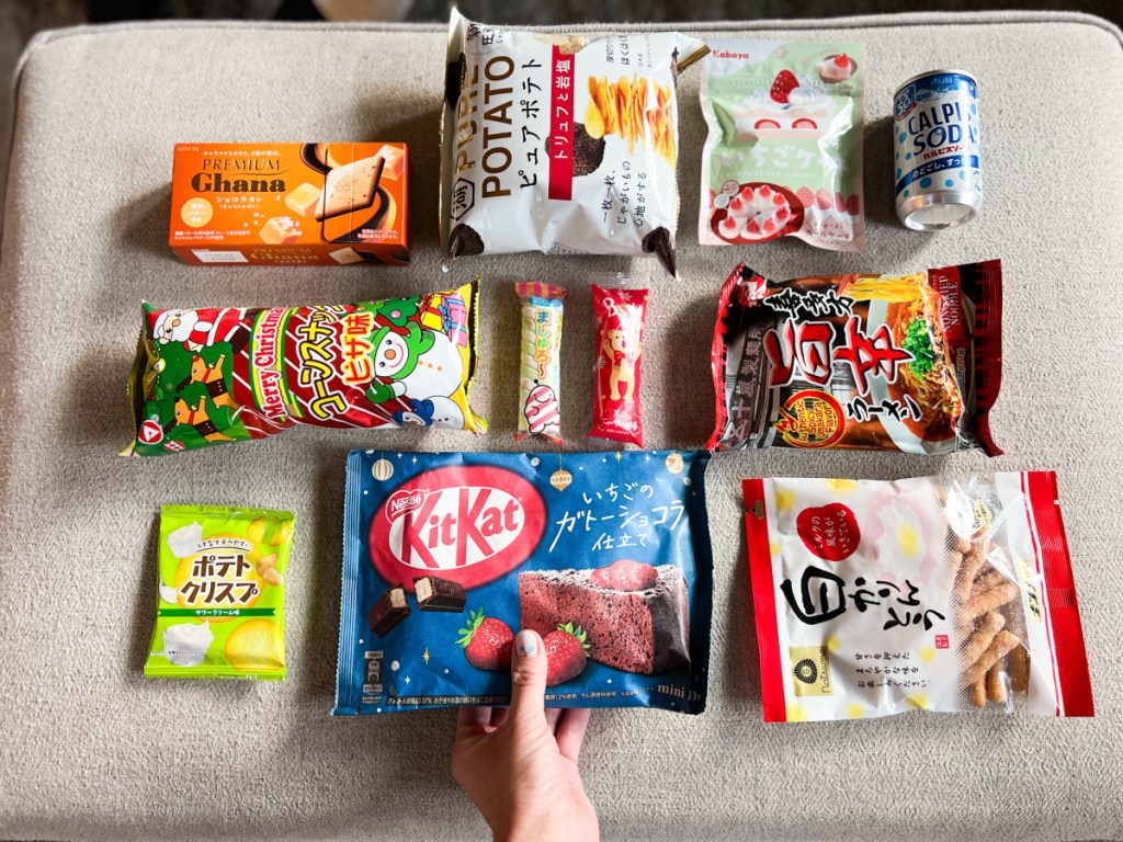 hand grabbing one of many japanese snacks